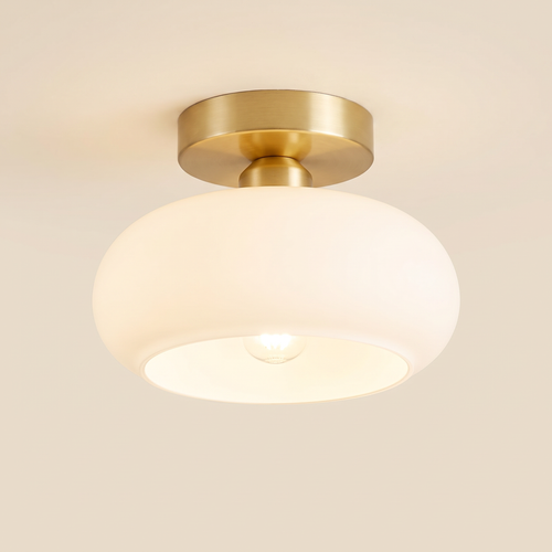 Stradbroke semi flush ceiling light with a rounded opal white glass mushroom shade on a brass finish ceiling plate, cream background