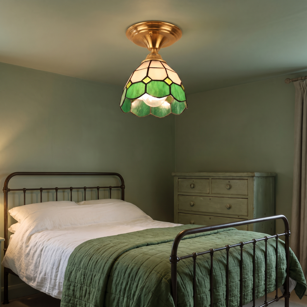 A lit Theberton green stained glass ceiling light in a bedroom