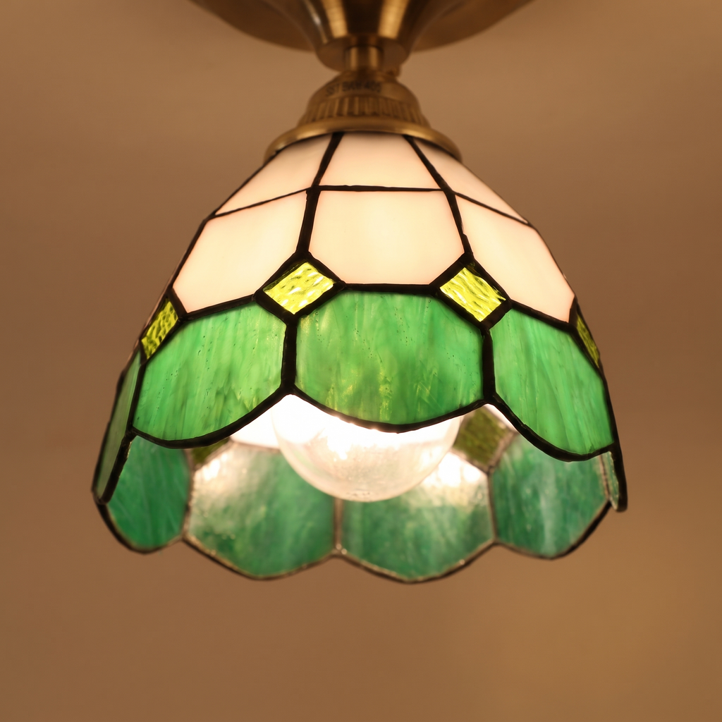Close up of a lit Theberton shade showing the white and green leaded glass and small glass jewels