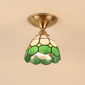 Theberton stained glass ceiling light with white and green leaded glass and a scalloped rim on an antique brass canopy, cream background