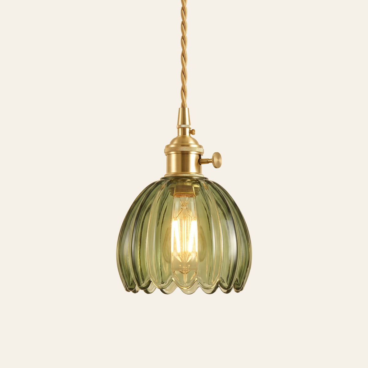 Ufford ribbed glass bud pendant light in sage green glass on a brass holder with a twisted cord, cream background