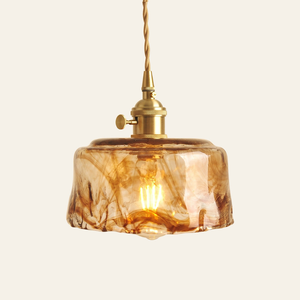 Walpole drum pendant light in amber glass with brown marbled swirls on a brass holder, cream background
