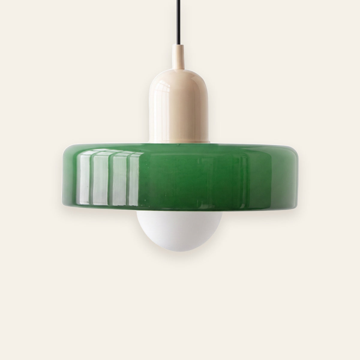 Welwyn mid century glass pendant light, green glass disc with a cream cap, on a cream background