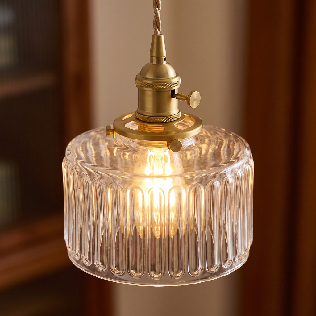 Close up of the clear Wenhaston ribbed glass shade with its scalloped rim and brass switch holder, lit