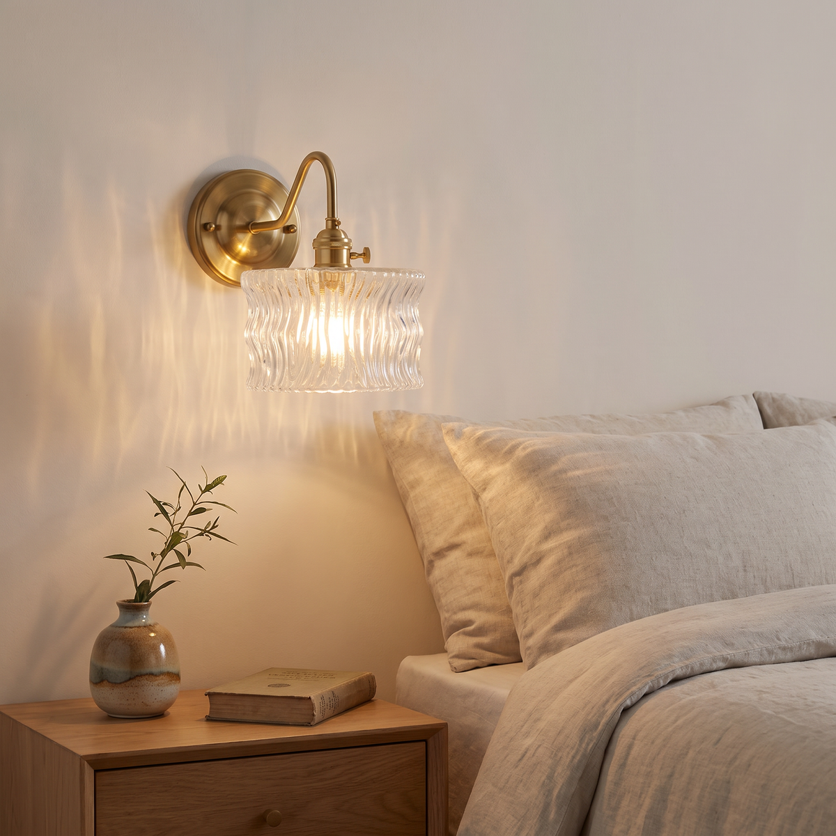 Westleton ripple glass wall light above a bedside table