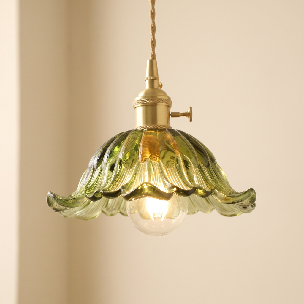 Close up of the green Wissett petal shade with its ruffled rim and globe bulb, lit
