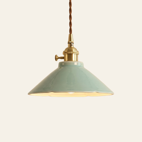 Wortham pendant light, a glossy celadon blue green glazed ceramic coolie shade on a brass finish holder with a turn switch, lit, cream background