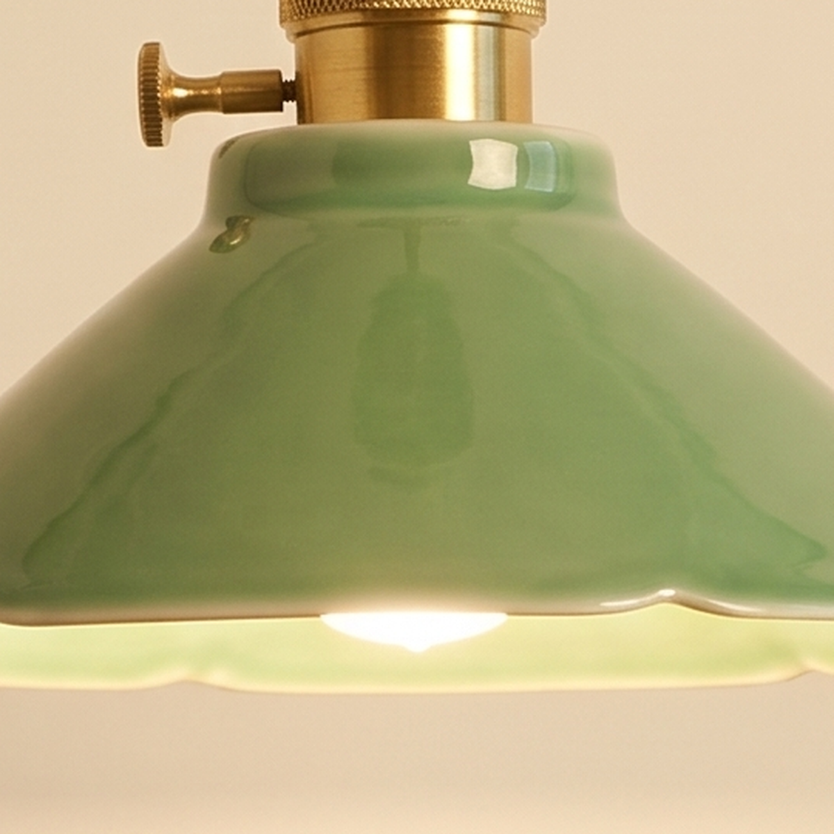 Close up of the glossy jade green glaze of the Wortham shade and its brass holder