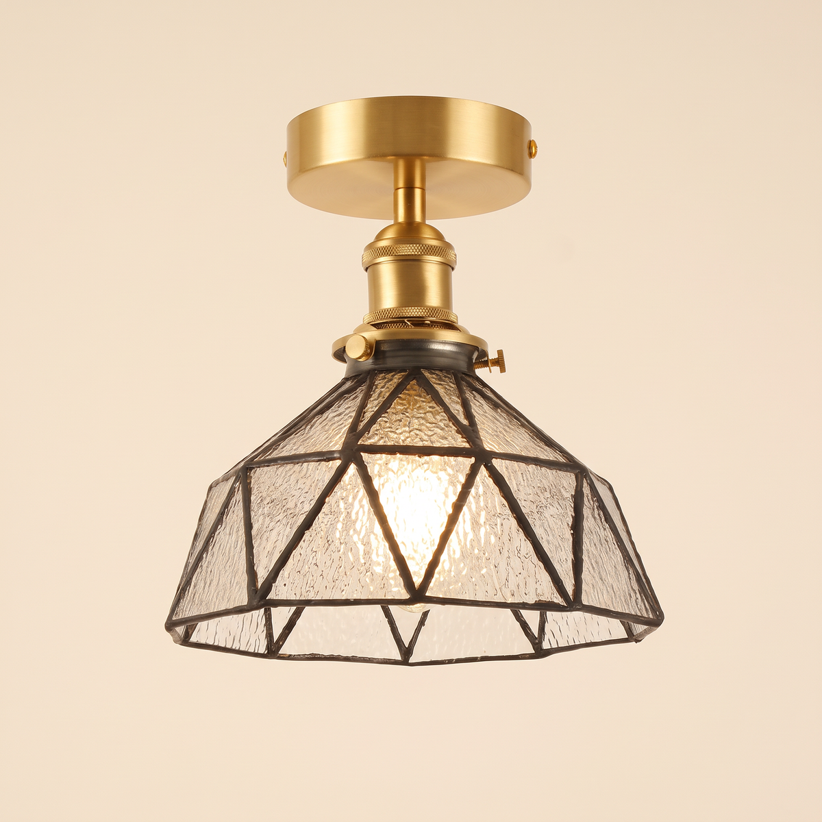 Wrentham semi flush ceiling light with a faceted dome of clear textured glass in geometric leading, brass fitting, cream background