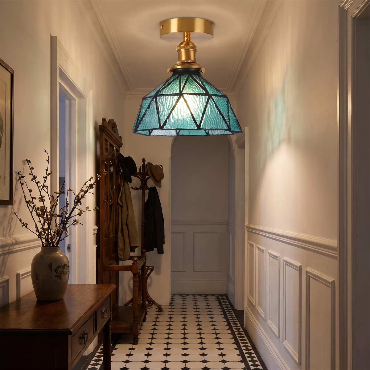 A teal Wrentham stained glass ceiling light lit in a Victorian hallway with a tiled floor