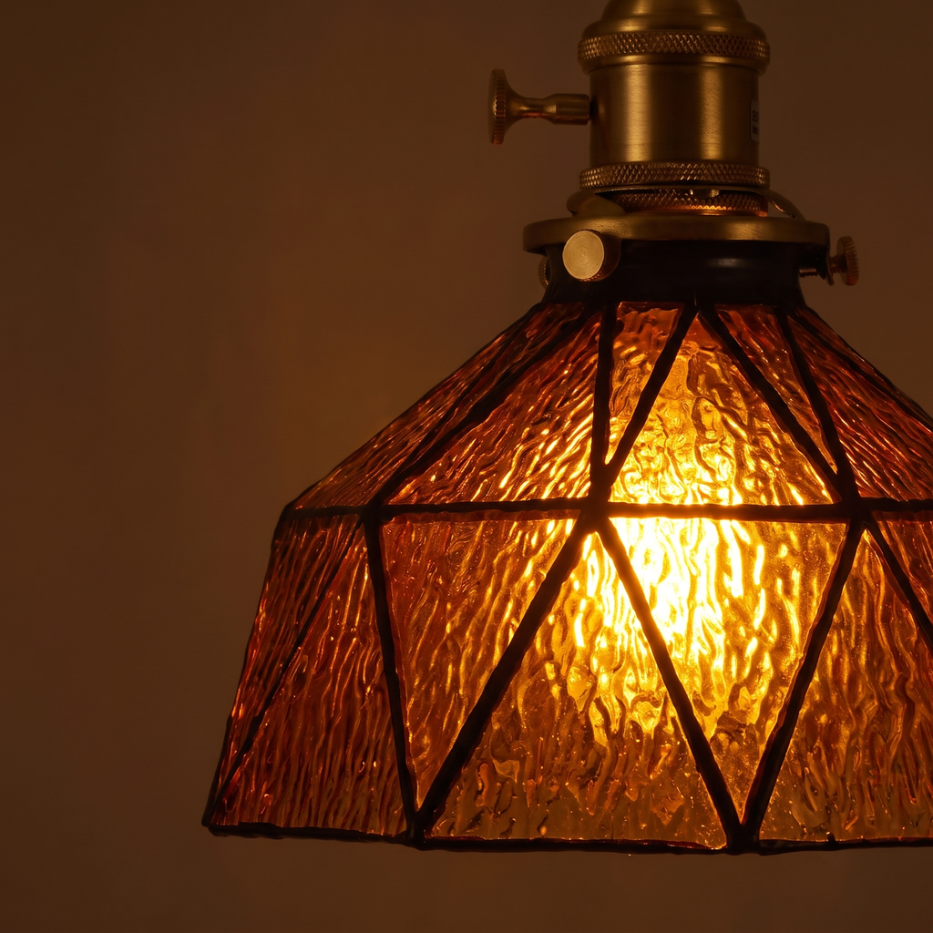 Close up of a lit Wrentham shade showing the rippled amber glass panels and dark geometric leading